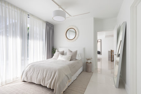 Luxurious, cozy bedroom in a high-end Apartment with natural light, elegant and cozy furniture.の写真素材