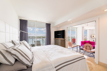 Luxurious, cozy bedroom in a high-end condo with natural light and elegant furniture.の写真素材