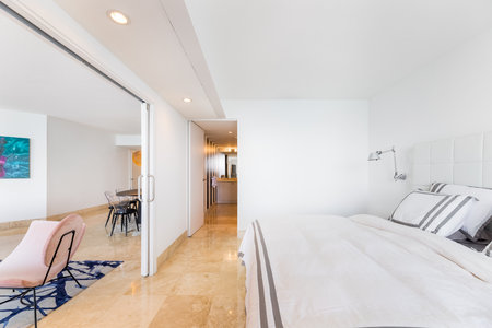 Luxurious, cozy bedroom in a high-end condo with natural light and elegant furniture.の写真素材