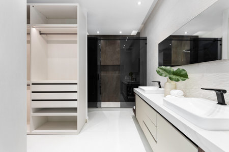 Beautiful photos of the interior of a Building. Clean, modern bathroom with refreshing shower, reflecting mirror, and sleek tiles.の写真素材