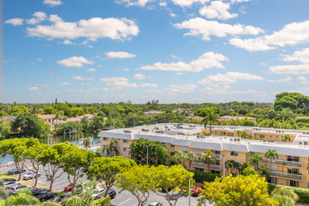 Photoshoot Footage of Aerial Drone view in Florida, Usa, showcasing skyline with multiples buildings in a water canal surrounded with abundant vegetantion a perfect blue sky.の写真素材