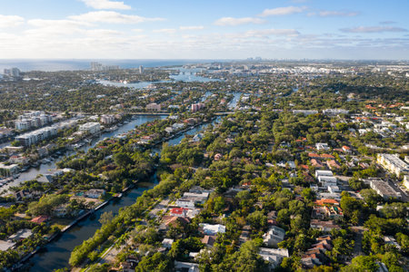 Photoshoot Footage of Aerial Drone view in Florida, Usa, showcasing skyline with multiples buildings in a water canal surrounded with abundant vegetantion a perfect blue sky.の写真素材