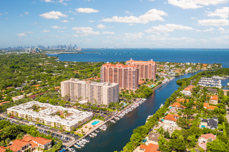 Photoshoot Footage of Aerial Drone view in Florida, Usa, showcasing skyline with multiples buildings in a water canal surrounded with abundant vegetantion a perfect blue sky.の写真素材