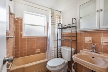 Interior of a bathroom with beige tile walls and brown bathtubの写真素材