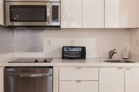 interior of new modern kitchen with white cabinets and stainless steel appliancesの写真素材