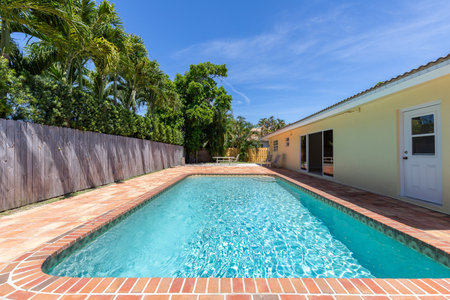 Swimming pool in the backyard of a private house with wooden fenceの写真素材