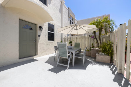 Outdoor patio with table, chairs and umbrella in luxury house.の写真素材