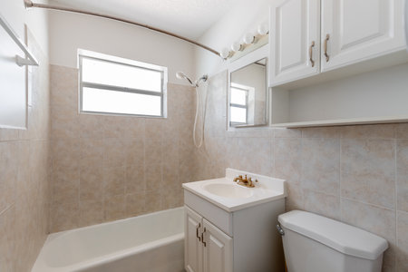 Interior of a bathroom with tiled walls and white bathtubの写真素材