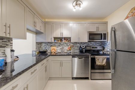 Kitchen interior with white cabinets and black granite countertop. Northwest, USAの写真素材