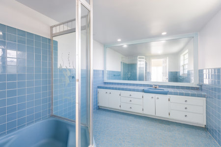 Interior of a bathroom with blue tile floor and white bathtubの写真素材