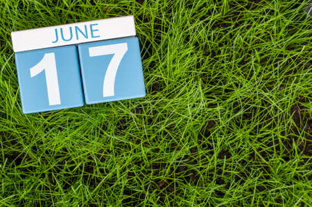 June 17th. Image of june 17 wooden color calendar on greengrass lawn background. Summer day, empty space for text.の写真素材