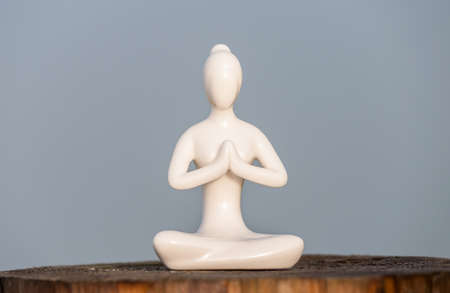 Figure of beautiful young girl meditating and do yoga on wooden surface.の写真素材