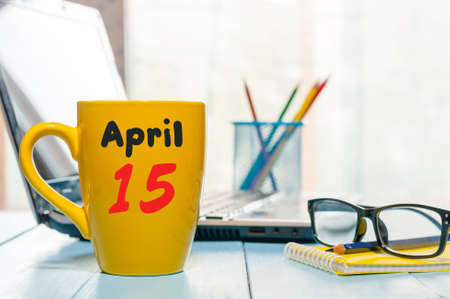 April 15th. Day 15 of month, calendar on business office background, workplace with laptop and glasses. Spring time, empty space for text.の写真素材