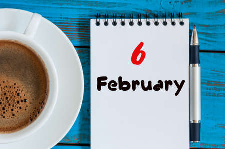 February 6th. Day 6 of month, calendar in notepad on wooden background near morning cup with coffee.の写真素材