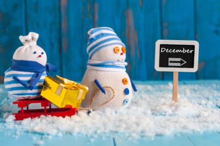Word December written on direction sign and couple Snowman with red sled. Christmas, New year decorationsの写真素材