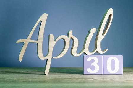 April 30th. Day 30 of month, daily calendar on wooden table with purple or violet background. Spring time themeの写真素材