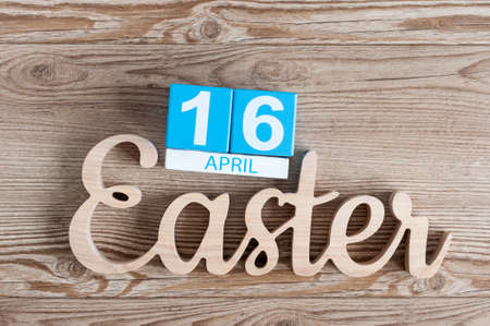 Easter carved wooden inscription with cubes calendar April 16th. Holiday background. day 16 of month
