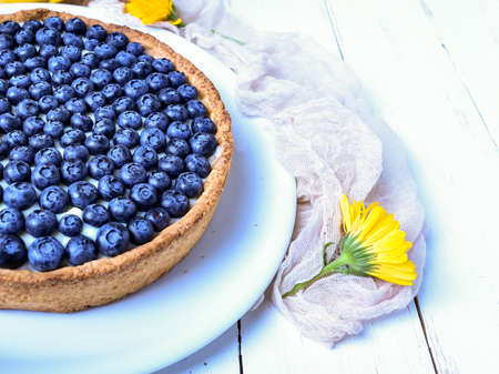 Blackberry pie and on rustic wooden table with yellow flower. Restaurant or home cooking concept.の写真素材