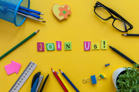 JOIN US - CONCEPT text on yellow work place, office background with suppliesの写真素材