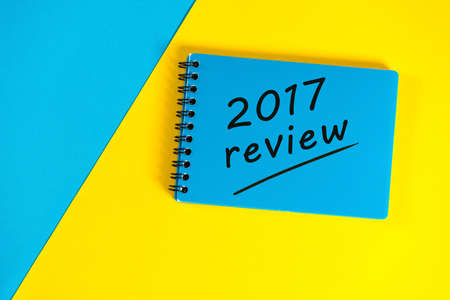 Blue notepad with review 2017. New year 2018 - Time to summarize and plan goals for the next year....