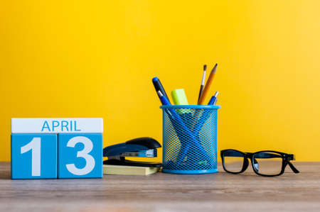 April 13th. Day 13 of month, calendar on business office table, workplace with yellow background. Spring timeの写真素材