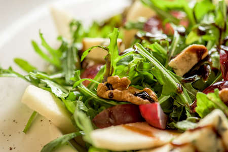 Leaf vegetable salad with cheese, grapes, walnuts and tasty sauce. Healthy, diet foodの写真素材