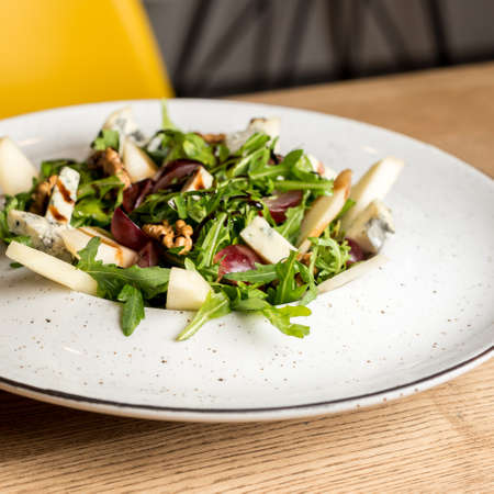 Leaf vegetable salad with cheese, grapes, walnuts and tasty sauce. Healthy, diet food.の写真素材