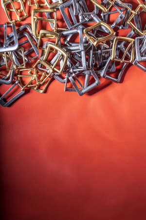 Belt buckles and coral leather background with empty space for mockup, template and text