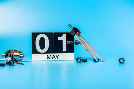 Labour day. May 1st. Day 1 of may month, calendar on blue background with toolsの写真素材
