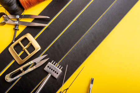 Leather working or Leather craft. Black tanned leather on leather craftmans work desk . Working...