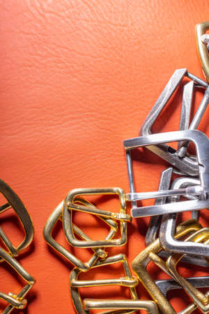 Belt buckles and coral leather background with empty space for mockup, template and textの写真素材