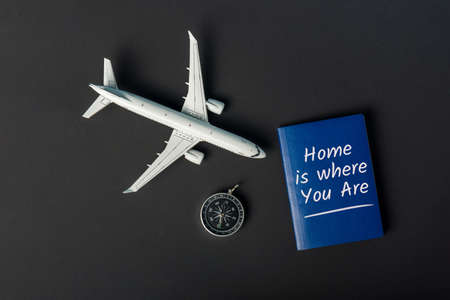 Home is where you are. Wanderlust and travel concept. Aircraft with compas on black background.の写真素材