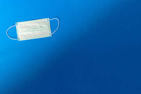 Medical Disposable Face Mask with blue copy space background. Covid-19 - Coronavirus pneumoniaの写真素材