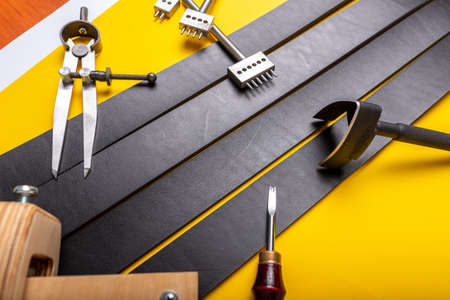 Sewing process of the leather belt. Tools, materials and accessories for leather workshop. Vintage sewing industrial.の写真素材