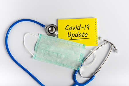 Stethoscope, Face mask with words COVID-19 UPDATE on white background. Coronavirus concept and...