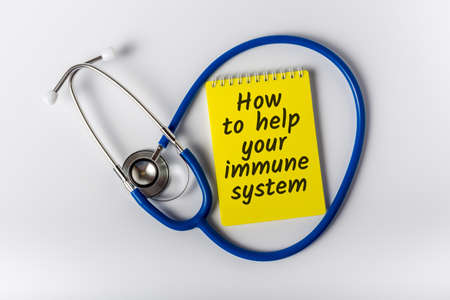 How to help your immune system - message on notepad near Stethoscope. Boost immune system as medical concept.の写真素材