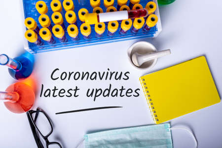 Research lab background with note COVID-19 latest UPDATES. Coronavirus concept and quarantineの写真素材