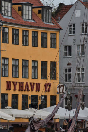 Copenhagen, Denmark - Juli 1, 2020 Street view of the colorful building in Nyhavn in Cophenhagen with people walking the street in front. High quality photoのeditorial素材