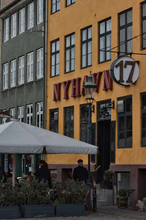 Copenhagen, Denmark - Juli 1, 2020 Street view of the colorful building in Nyhavn in Cophenhagen with people walking the street in front. High quality photoのeditorial素材
