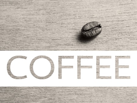 Roasted Coffee Beans on wood texture with text, retro monotone color backgroundの写真素材