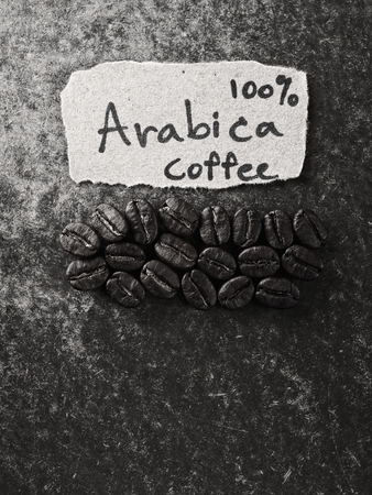 Coffee crop beans with text paper on wood texture, monotone  backgroundの写真素材