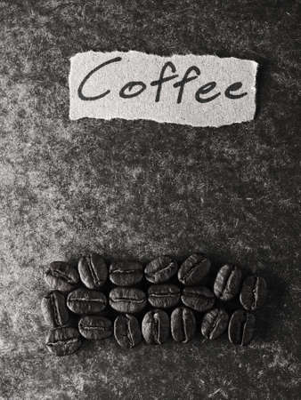 Coffee crop beans with text paper on wood texture, monotone  backgroundの写真素材