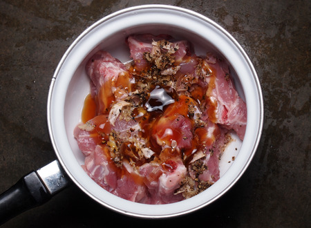 Raw pork meat with garlic pepper and shell sauce in pot before cookingの写真素材