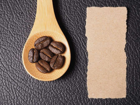 Coffee crop beans on bamboo spoon and leather texture backgroundの写真素材