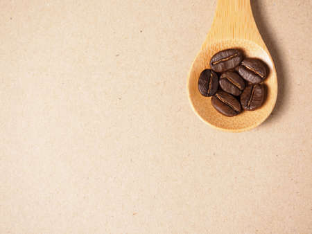 Coffee crop beans on  bamboo spoon and paper texture backgroundの写真素材