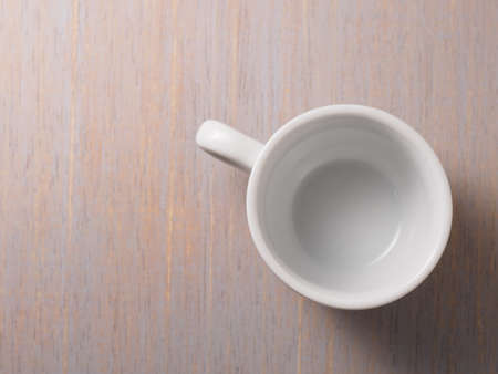 Empty white cup on wood texture backgroundの写真素材