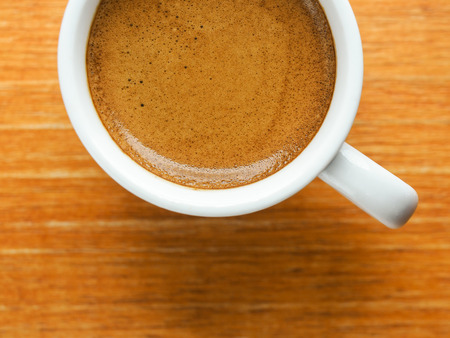 Cup of hot espresso coffee on wooden textureの写真素材