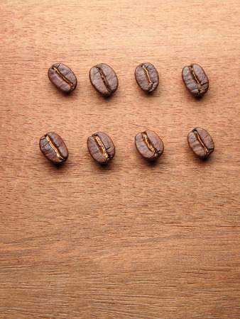 Coffee crop beans on wood texture backgroundの写真素材