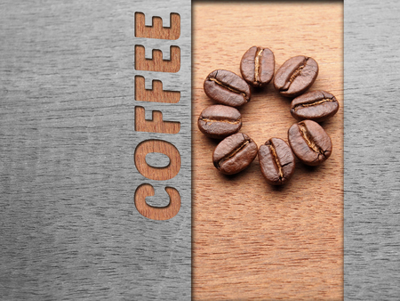 Coffee crop beans on wood texture with coffee text backgroundの写真素材