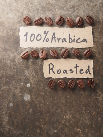 Coffee crop beans with 100 percent arabica  paper on wood texture backgroundの写真素材